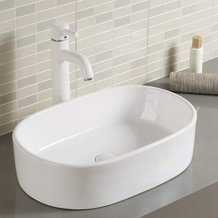 Lavabo de baño blanco de forma ovalada sobre encimera